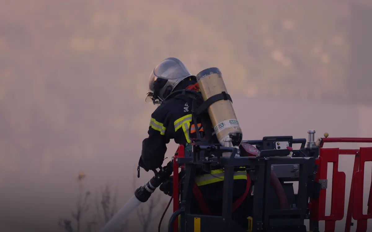 Sapeur-pompier en intervention depuis la nacelle d'un camion
